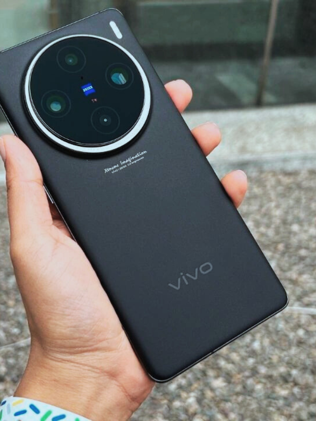 Hand holding Vivo X200 Ultra in black color with Zeiss camera system outdoors.