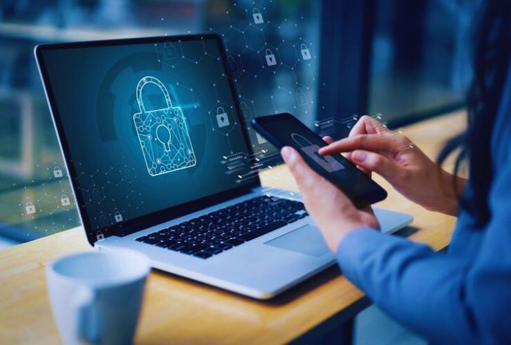 Person using AI-powered cybersecurity tools on smartphone and laptop for smart automation and data protection