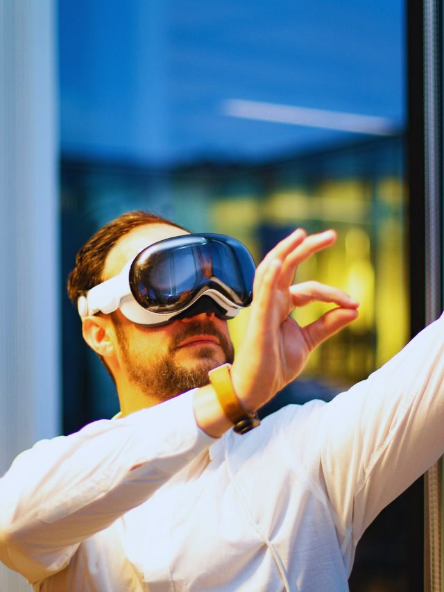 Man wearing futuristic AR glasses interacts with invisible digital content in a modern setting, illustrating how augmented reality is transforming life in the U.S. in 2025.
