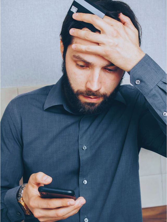 Businessperson holding a credit card and smartphone, illustrating digital security risks and data breach concerns in the US.